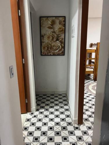 un pasillo con suelo de baldosa y una pintura en la pared en Casa aconchegante em Ubatuba, en Ubatuba