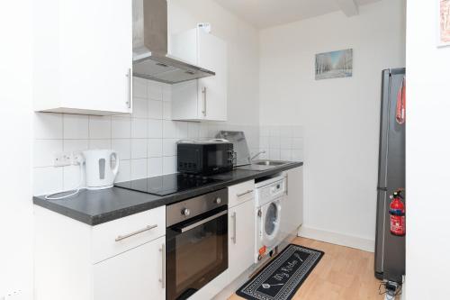 a kitchen with white appliances and a black counter top at Amazing Lodge in Southampton