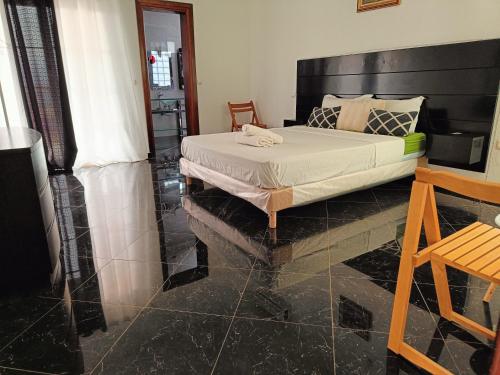 a bedroom with a bed with a black tiled floor at Casa Miami in Tarrafal