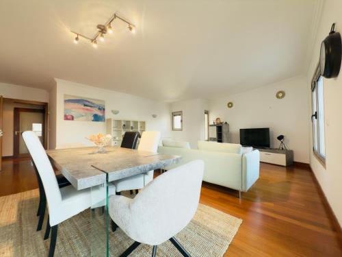 a dining room and living room with a table and chairs at Expo Luxury apartment in Lisbon