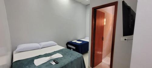 a small room with a bed and a television at Quarto suíte 8, cama casal1, cama solteiro 1 in Marabá