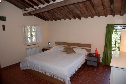 a bedroom with a white bed and a window at Villa Susana in Pieve di compito