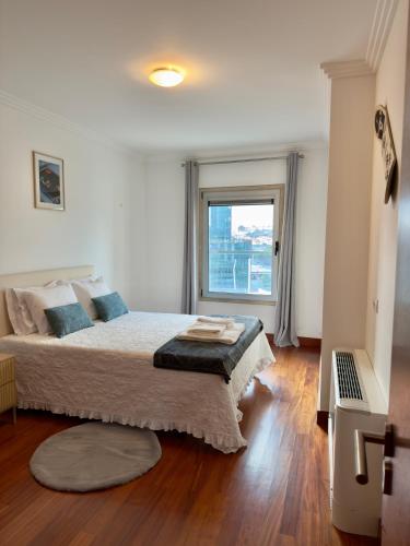 a bedroom with a large bed and a window at Expo Luxury apartment in Lisbon