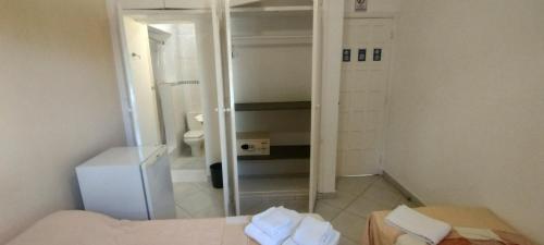 a small bathroom with a toilet and a mirror at Suítes Casa Branca in Guarujá