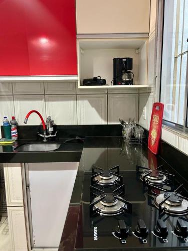 a kitchen with a stove and a counter top at Apartamento elegante a 1km do centro de Aracruz wifi gratuito garagem hacht cozinha equipada totamente individual in Aracruz