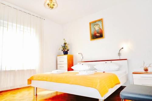 トロギールにあるHouse Mariposa Trogir-Segetの黄色い毛布が掛けられたベッドのある寝室