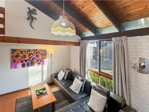 a living room with a couch and a table at 'Broulee Break' -2-Bed Beach House with Games Room in Broulee