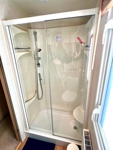 a shower with a glass door in a bathroom at The Puffins Rest in Tenby