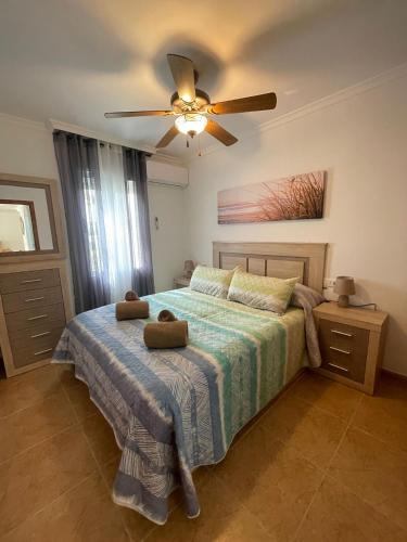 ein Schlafzimmer mit einem Bett mit Deckenventilator in der Unterkunft EL ESCONDITE Bahía de Vera Naturista in Playas de Vera