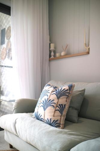 a pillow sitting on a couch in a living room at Newly Renovated, walk to beach, jump in pool in Gold Coast