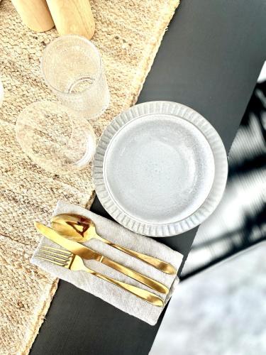 a table with two plates and two glasses and chopsticks at Newly Renovated, walk to beach, jump in pool in Gold Coast