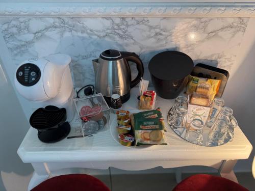 a table with a coffee pot and food on it at San Massimo Apartment - Piazza Duomo L'Aquila in LʼAquila