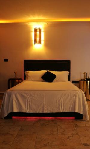 a bedroom with a white bed with a black bag on it at OLGA Luxury Suite I 5 min from airport I central location I traditional village in Luqa