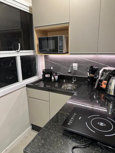 a kitchen with a counter top with a microwave at Studio 401 Santa Casa UFRGS Estacionamento proximo in Porto Alegre