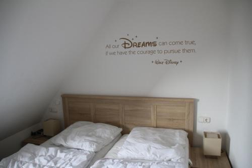 um quarto com uma cama com uma placa na parede em Apartment Yoursylt One em Westerland