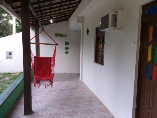 a red hammock hanging from a wall in a room at Bromelias Imbassai in Imbassai
