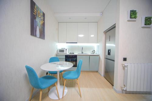 una piccola cucina con tavolo e sedie blu di Nova Trio a Tbilisi City