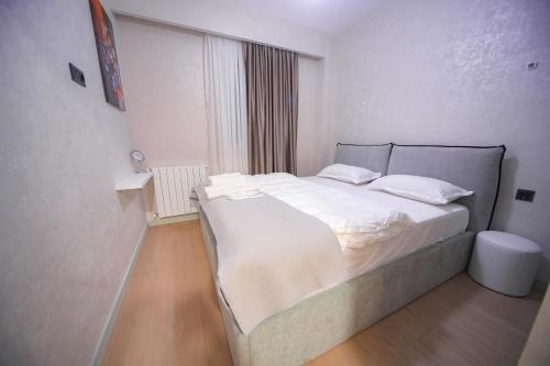 una camera da letto con un grande letto bianco e una finestra di Nova Trio a Tbilisi City