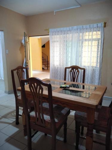 a dining room table with two chairs and a glass top at Casa Ana Liz in Oaxaca City