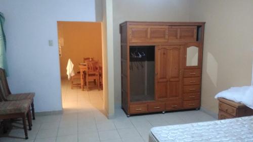 a room with a wooden cabinet and a dining room at Casa Ana Liz in Oaxaca City