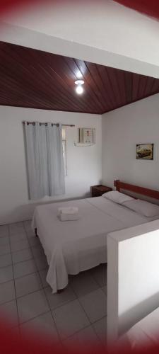 a bedroom with a large white bed in a room at Bromelias Imbassai in Imbassai