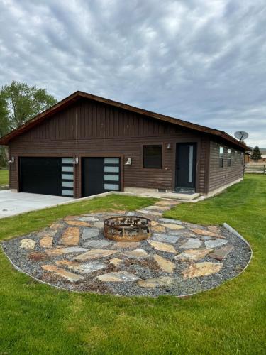 a building with a large stone circle in the grass at Sportsman Lodge Melrose MT in Melrose