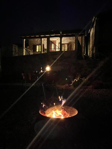 a fire pit in the middle of a yard at night at Casa María da Reza in Ribadavia