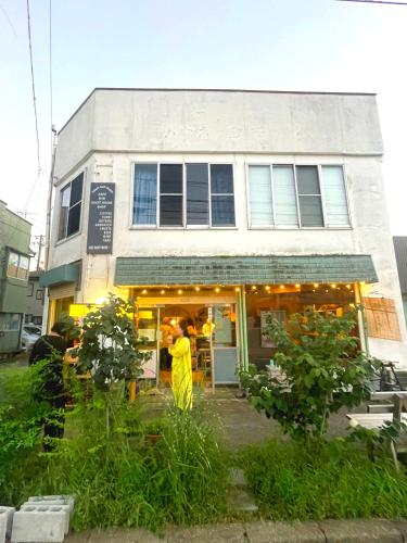a building with a person standing outside of it at CORNER SHOP Miyota in Miyota