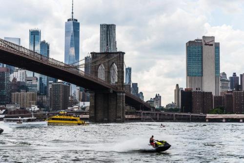 a person in a boat in the water near a bridge at 2BR, King Bd, Free Prkn, Gym, NYC View, 8min Train in East Orange