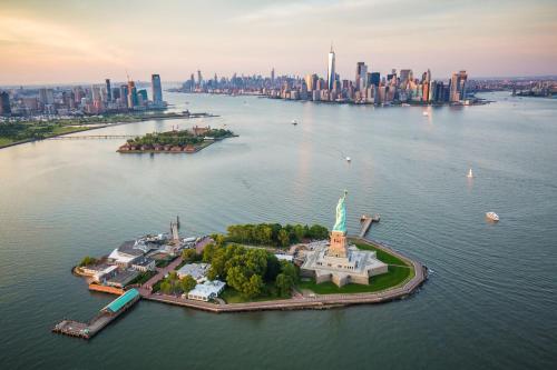 an island in the water with a statue of liberty at 2BR, King Bd, Free Prkn, Gym, NYC View, 8min Train in East Orange