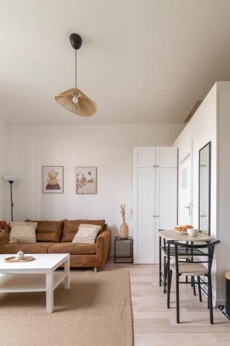 un salon avec un canapé et une table dans l'établissement Appartement cosy proche de Paris, à Asnières-sur-Seine