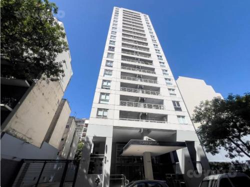 a tall white building with a parking lot in front of it at Departamento 3 amb para 5 personas con gimnasio, cochera y piscina in Buenos Aires