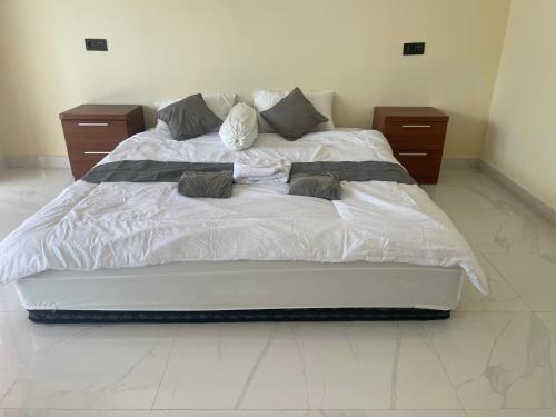 a large bed with white sheets and pillows on it at Saris Sweet Dream Villa in Kubupenlokan