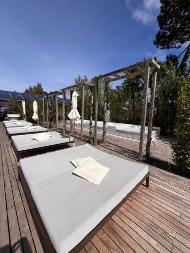 a row of white tables on a wooden deck at YOO Punta del Este in Punta del Este