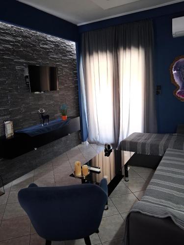 a blue room with a bed and a couch at Maka's Design Suite-Trikala in Tríkala