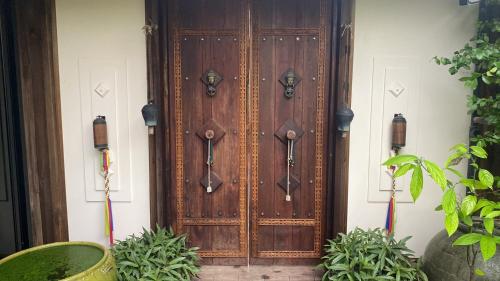 a wooden door on a building with some plants at Mintys Folly 2 in Ban Man