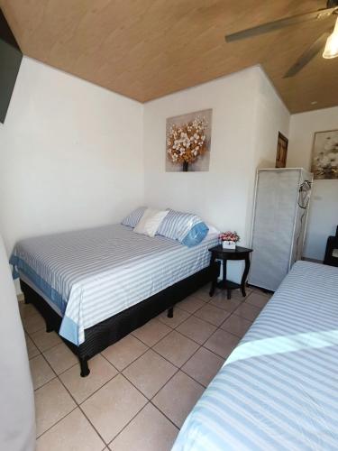 una camera da letto con due letti, un tavolo e un quadro di Dinos House a Concepción de Ataco