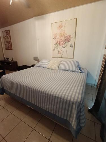 1 dormitorio con 1 cama con edredón a rayas en Dinos House, en Concepción de Ataco