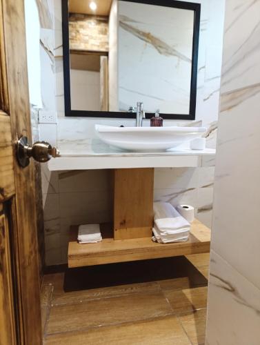 un bagno con lavandino e specchio di Dinos House a Concepción de Ataco