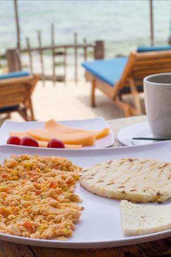 a plate of food with bread and cheese on a table at Cabaña Coral Azul in Playa Blanca