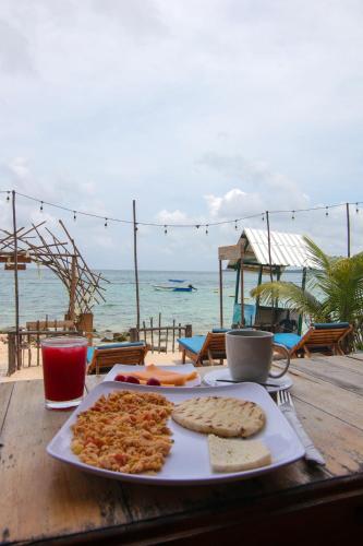 a plate of food on a table next to the beach at Cabaña Coral Azul in Playa Blanca