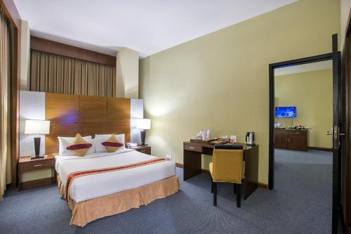 a hotel room with a bed and a desk at Rose View Hotel in Sylhet