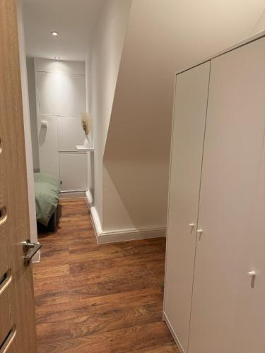 a room with a large glass cabinet next to a stairs at Stylish modern apartment in London