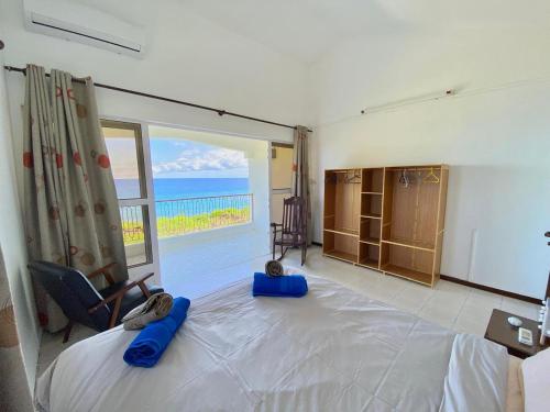a bedroom with a bed with a view of the ocean at Cosy Escape in Flic-en-Flac