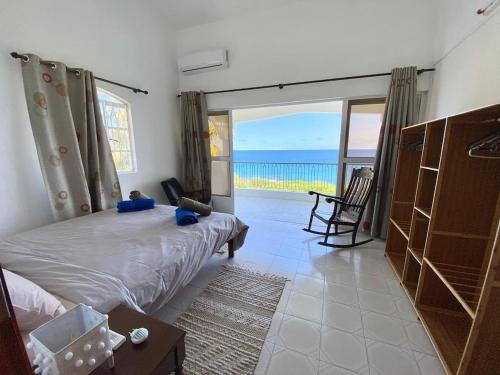 a bedroom with a bed and a view of the ocean at Cosy Escape in Flic-en-Flac