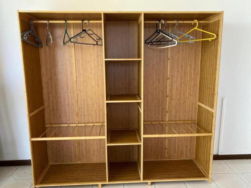 a wooden closet with wooden shelves and hangers at Cosy Escape in Flic-en-Flac