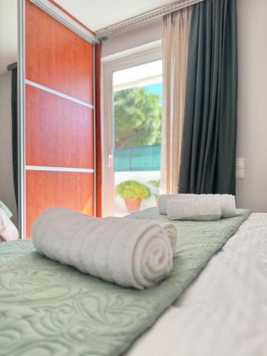 a bed with two towels on it with a window at HalCyon-On the blue in Nea Makri