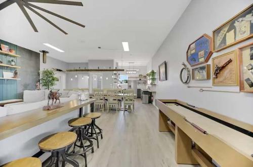 a restaurant with tables and stools in a room at 25 Min to Grand Canyon Shuffleboard Fire Pit in Valle
