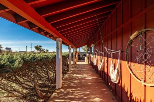 a red building with a sidewalk next to a field at 25 Min to Grand Canyon Shuffleboard Fire Pit in Valle