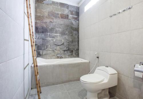 ケロボカンにあるSaren Guesthouse Baliのトイレと浴槽付きのバスルーム